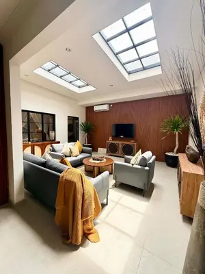 a living room with couches and a tv and skylight at de CINTA Villa - KUTA - 6 bedrooms - Heart of Kuta in Kuta