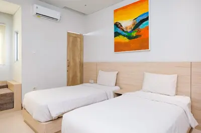 two beds in a room with white walls at Lega Legi Town House Seminyak by The Lavana in Seminyak