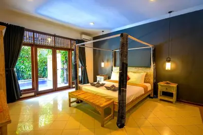 a bedroom with a canopy bed and a bench at Villa SANKET - KUTA - 6 bedrooms - 6 bathrooms - Great Location in Kuta