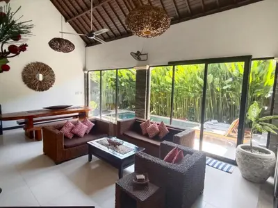a living room with a couch and chairs and windows at Villa CRIS - Heart of LEGIAN 3 Bedrooms, 3 Bathrooms in Legian