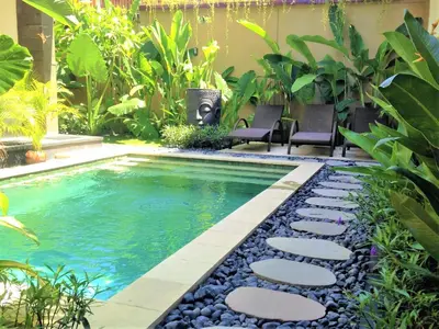 a swimming pool in the middle of a garden at OASIS 66 Villa - Heart of Legian/Seminyak - Double Six in Seminyak
