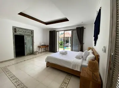 a bedroom with a bed and a large window at Villa Biru - 500m Batubelig beach in Canggu