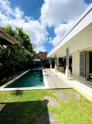 a swimming pool in front of a house at Villa Biru - 500m Batubelig beach in Canggu