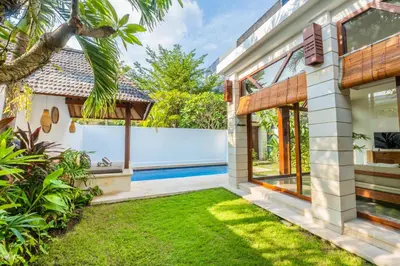 a house with a garden and a swimming pool at Canggu Escape Villa By Island Escape in Canggu