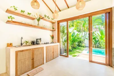 an open kitchen with a view of the pool at Villa Tokyo - 3 BDR Private Villa - 3 min walk to KU DE TA beach in Kuta