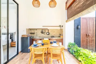 a dining room with a wooden table and chairs at Kamaratih Villas by Maheswara in Legian