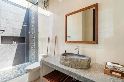 a bathroom with a sink and a toilet and a mirror at Kamaratih Villas by Maheswara in Legian