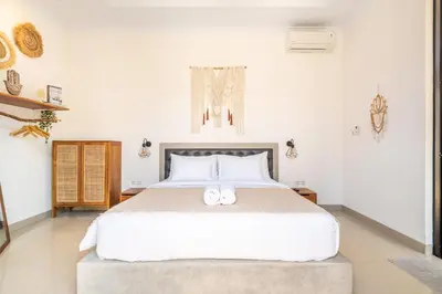 a bedroom with a large bed with two towels on it at Kamaratih Villas by Maheswara in Legian