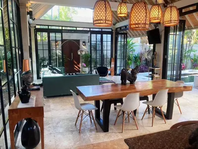 a dining room with a wooden table and chairs at villa LA PLAYA in Seminyak