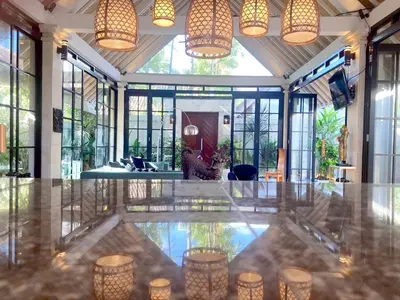 a large room with a lobby with a table and lights at villa LA PLAYA in Seminyak