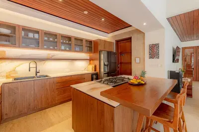a kitchen with wooden cabinets and a wooden counter top at Villa Dorado - Steps from Jimbaran Beach in Jimbaran