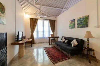 a living room with a couch and a table at Miracle Villa Sanur in Sanur
