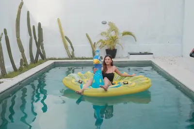 a woman is sitting on a raft in a pool at Villa Akmali Seminyak Basangkasa- 2 Bedrooms in Seminyak