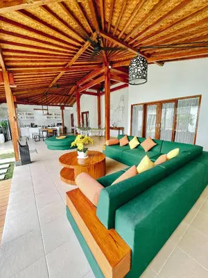 a living room with green couches and wooden ceilings at Villa Orked 3 with family room Seminyak in Seminyak