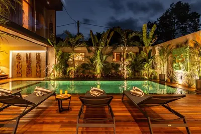 a resort with a pool and chairs and a building at PROMO Luxury 4bd Villa in HotSpot with Huge Private Pool in Seminyak