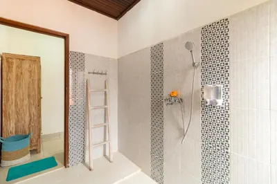 a bathroom with a shower with a mirror at Spacious and Quiet 2 Bd Villa with Pool and Projector in Kerobokan