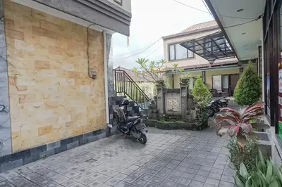 a motorcycle parked in front of a house at Taxa Uma Guest House in Kuta