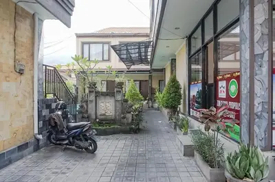 a motorcycle parked on a sidewalk next to a building at Taxa Uma Guest House in Kuta