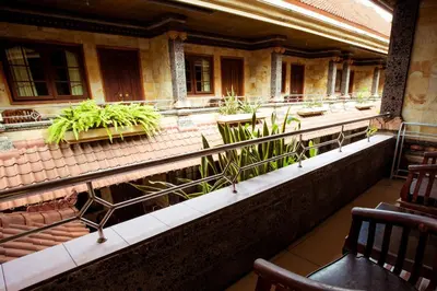 a balcony of an old building with potted plants at Segara Sadhu Inn Kuta by ecommerceloka in Kuta