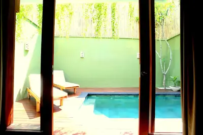 a view of a swimming pool through a sliding glass door at Jas Green Villas and Spa in Seminyak