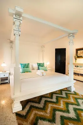 a white bed with a white canopy in a room at The Indies Estate in Sanur