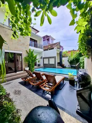 a patio with chairs and a swimming pool at Pondok DEWI Villa - LEGIAN - 6 Bedroom Villa - Great Location in Legian
