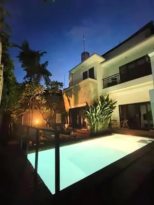 a swimming pool in front of a house at night at Pondok DEWI Villa - LEGIAN - 6 Bedroom Villa - Great Location in Legian