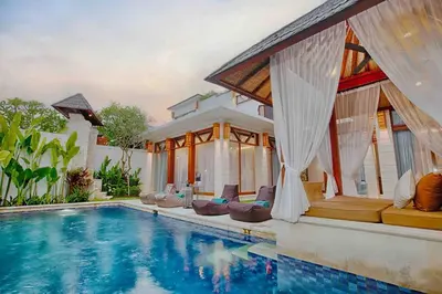 a villa with a swimming pool and a house at THE MILAGRO VILLA in Canggu