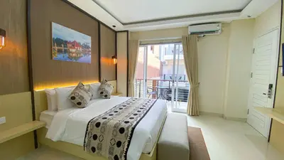 a hotel room with a bed and a balcony at Ultimate Residence Bali in Denpasar