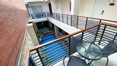 an empty balcony with chairs and a swimming pool at Ultimate Residence Bali in Denpasar
