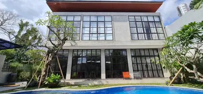 a large house with a swimming pool in front of it at Rumah Hadeka Petitenget in Seminyak