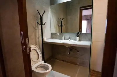 a bathroom with a toilet and a sink and a mirror at Villa Cleopatra Bali in Sanur