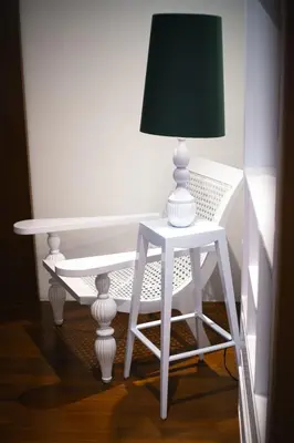 a white table with a lamp on a stool at Calm Villa in Seminyak