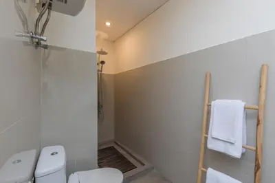 a bathroom with a white toilet and a shower at Villa Luna Rose in Seminyak