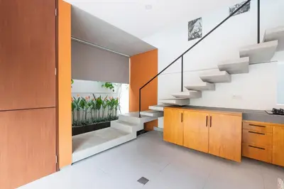 an open kitchen with a staircase in a house at THE COINS VILLA SEMINYAK in Seminyak
