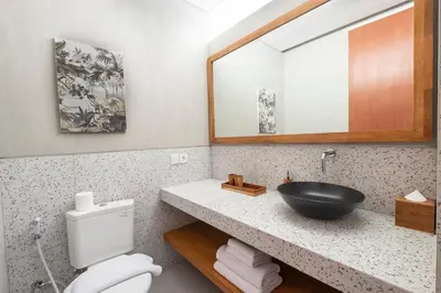 a bathroom with a black sink and a toilet at THE COINS VILLA SEMINYAK in Seminyak