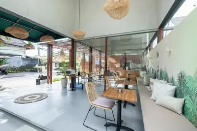 a restaurant with tables and chairs and windows at THE COINS VILLA SEMINYAK in Seminyak