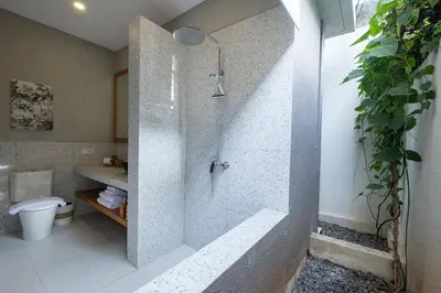 a bathroom with a shower with a toilet and a sink at THE COINS VILLA SEMINYAK in Seminyak