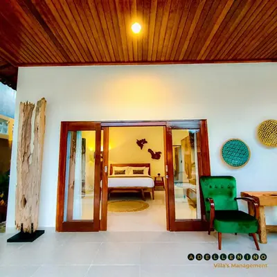 a living room with a bed and a green chair at CASA LUWIH Newly Renovated 2BR Villa with Private Pool in Seminyak in Seminyak