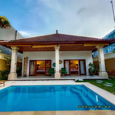a villa with a swimming pool in front of a house at CASA LUWIH Newly Renovated 2BR Villa with Private Pool in Seminyak in Seminyak