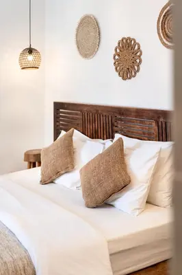 a bedroom with a bed with white sheets and pillows at Casa de Lupe 5 bedroom villa in Kerobokan in Seminyak