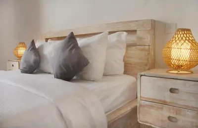 a bedroom with a bed with white sheets and pillows at CASA BISMA - 3 Bedroom Villa with Pool in LEGIAN in Seminyak