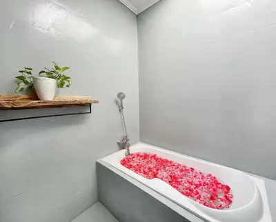 a bathroom with a bath tub filled with red flowers at CASA BISMA - 3 Bedroom Villa with Pool in LEGIAN in Seminyak
