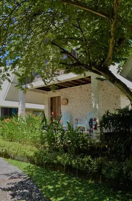 a house with blue chairs in the yard at Chanteak Bali - Stone House 1 in Jimbaran