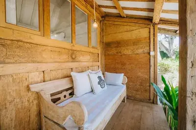 a bedroom with a bed in a wooden house at Chanteak Bali - Teak House 1 in Jimbaran