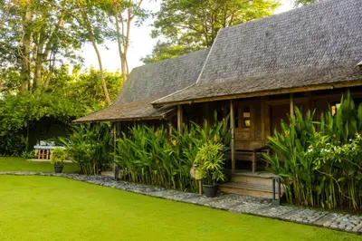 a house with a garden in front of it at Chanteak Bali - Teak House 1 in Jimbaran