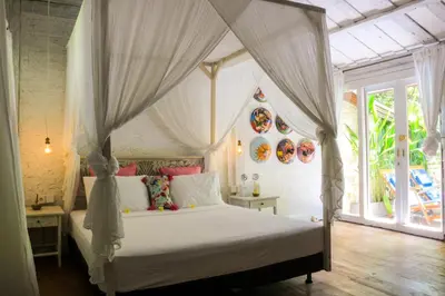 a bedroom with a bed with a canopy at Chanteak Bali - Teak House 2 in Jimbaran