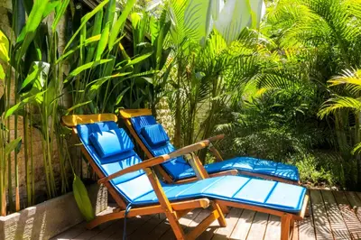 a pair of blue chairs sitting on a deck at Chanteak Bali - Teak House 2 in Jimbaran
