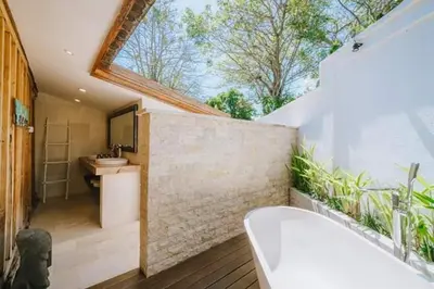 a bathroom with a bath tub and a sink at Chanteak Bali - Teak House 3 in Jimbaran