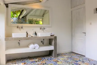 a bathroom with two sinks and a mirror at Chanteak Bali - White House 1 in Jimbaran